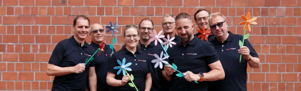 Gruppenfoto vom OK der CHOMA2025 mit bunten Windrädern in den Händen